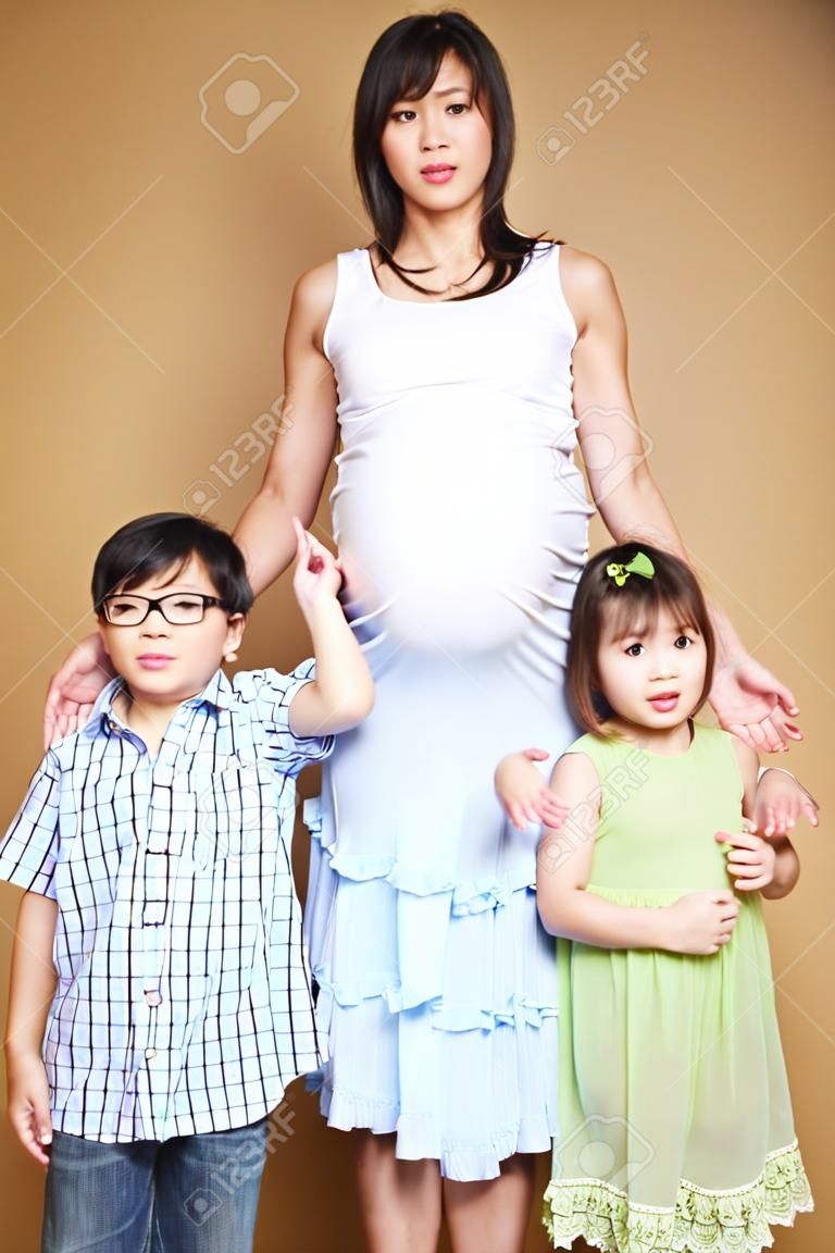 A shot of a pregnant Asian mother with her two kids