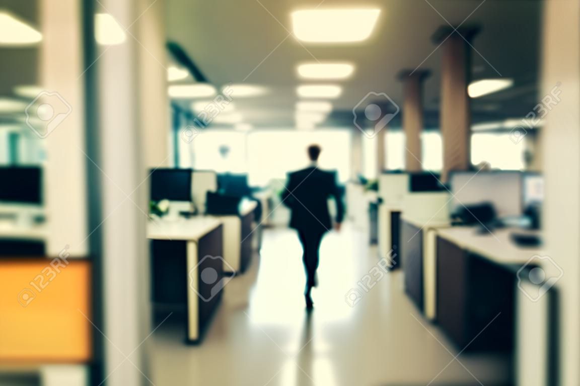 Blurred image of a businessman walking in the office. Toned.