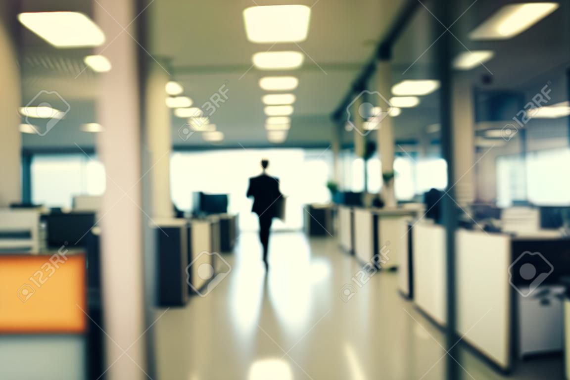 Blurred image of a businessman walking in the office. Toned.
