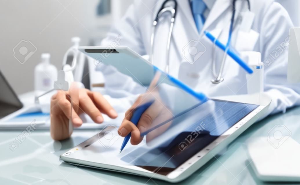 의사는 컴퓨터를 사용하여 디지털 태블릿 의료 의사 기술 태블릿에서 작업합니다.