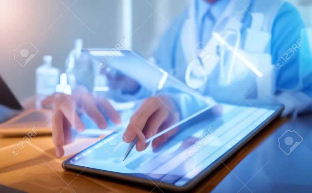 의사는 컴퓨터를 사용하여 디지털 태블릿 의료 의사 기술 태블릿에서 작업합니다.