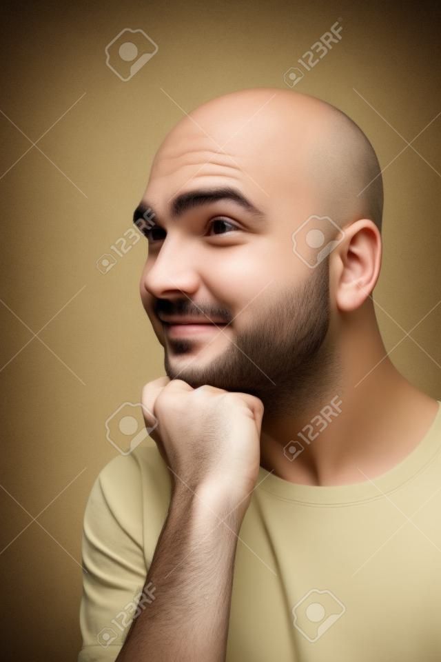 funny young man with bald head  is refacting