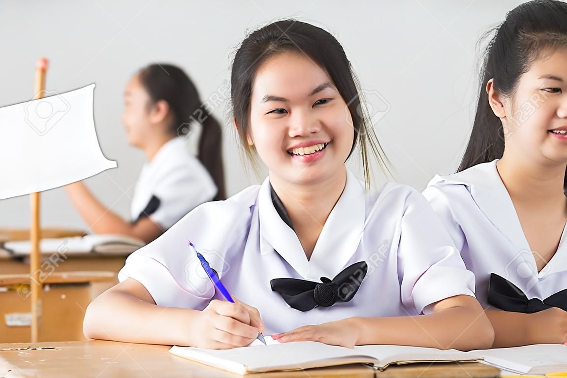 Smile young girl student reading and writing exam with not stress.