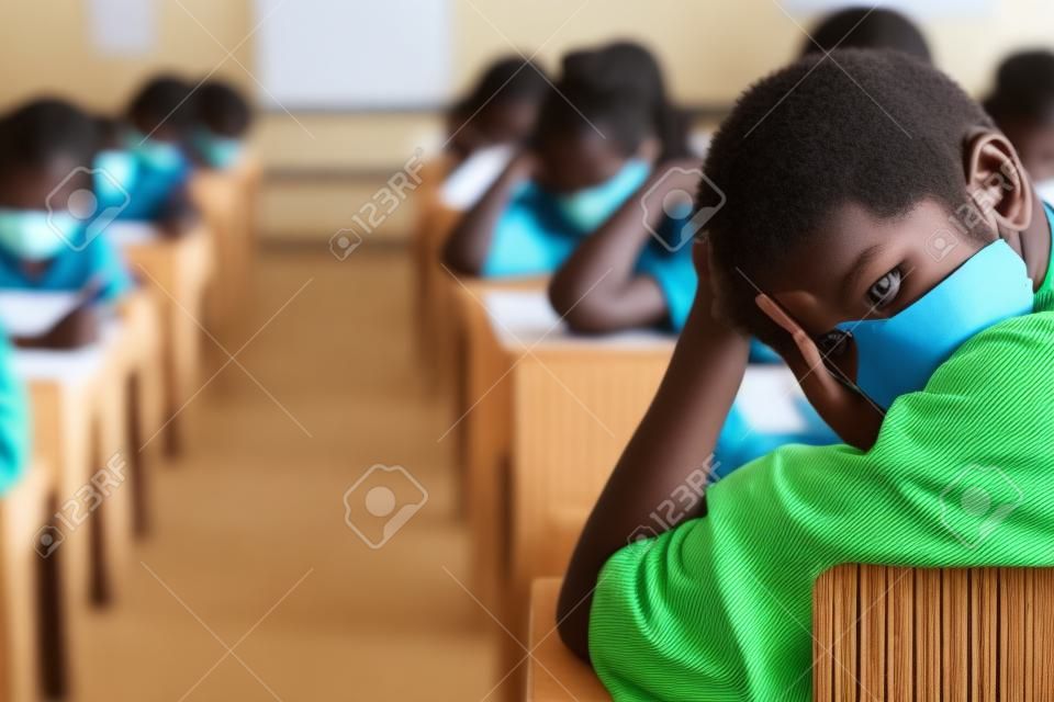 Alunos fazendo exercícios de folhas de respostas de exames em sala de aula da escola com estresse.