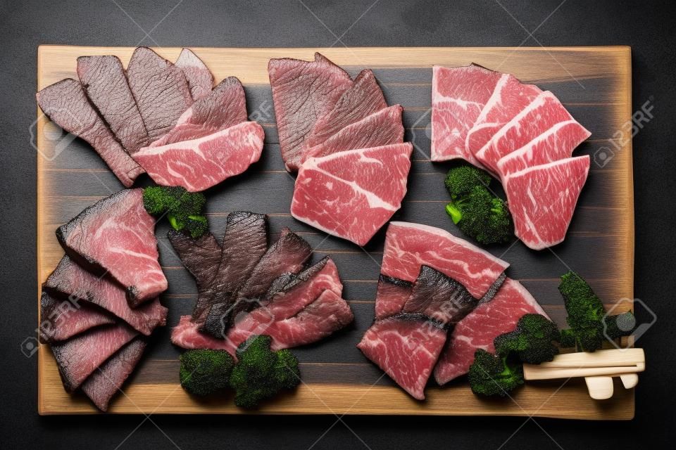 Top view of Premium Rare Slices many parts of Wagyu A5 beef with high-marbled texture on stone plate served for Yakiniku (Grilled Meat).