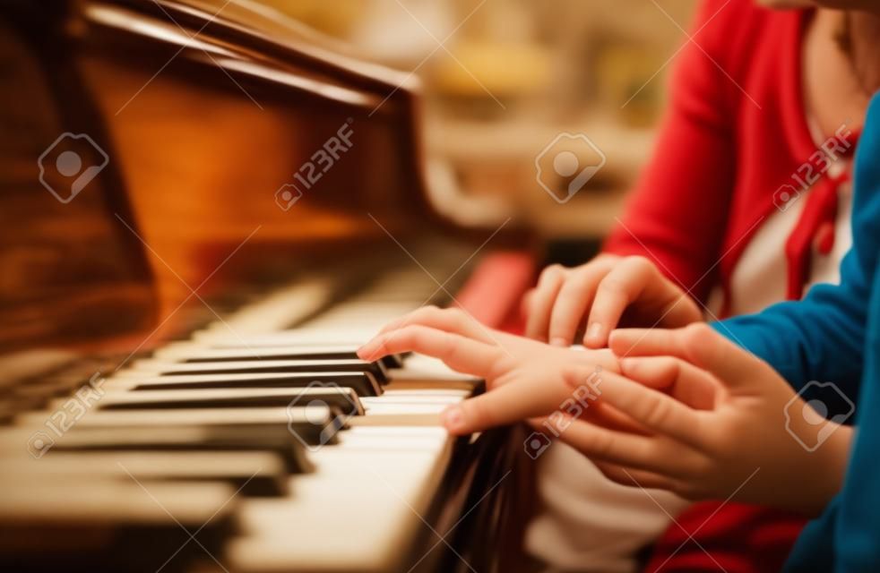 mão experiente do velho professor de música ajuda o aluno da criança