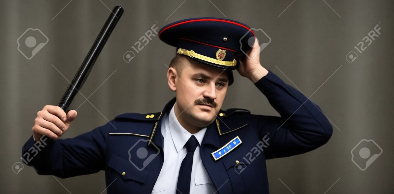 un hombre con uniforme de policía ruso con un bastón. traducción al inglés de "policía"
