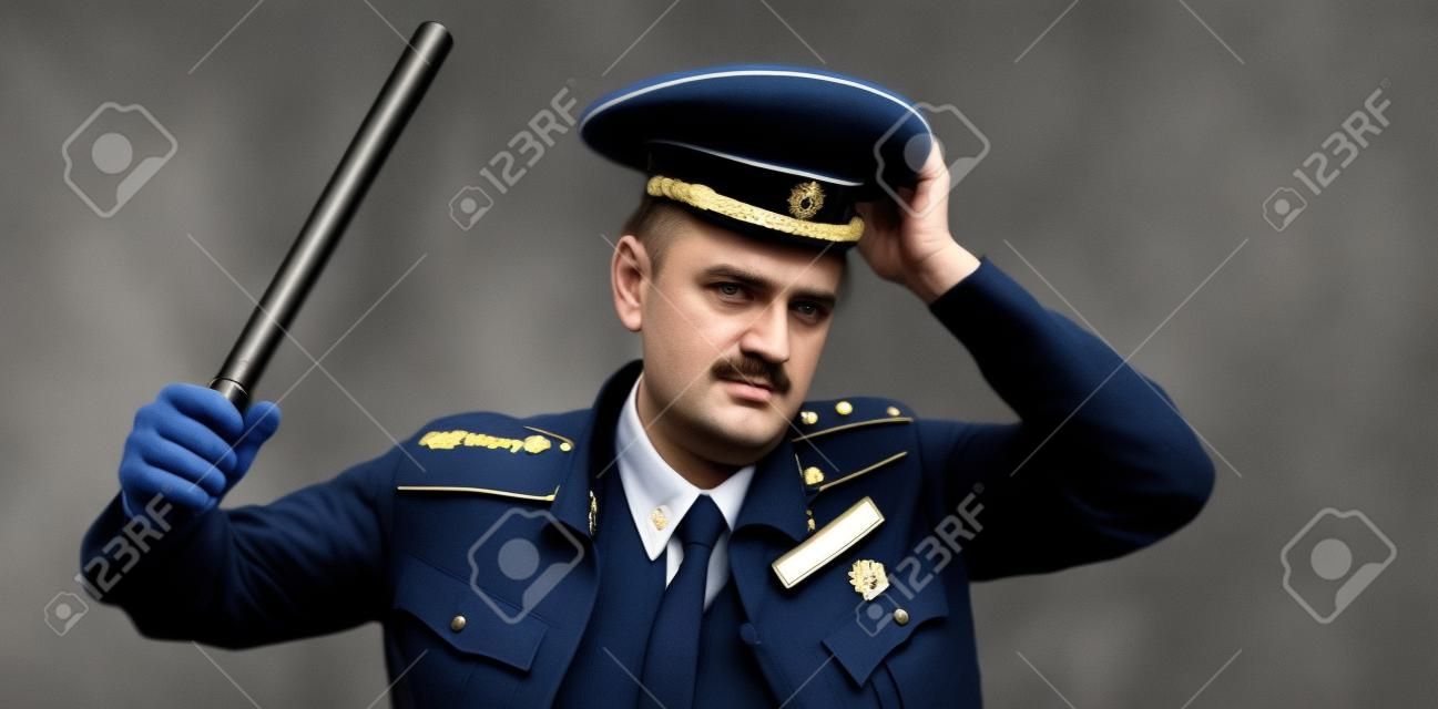 un hombre con uniforme de policía ruso con un bastón. traducción al inglés de "policía"