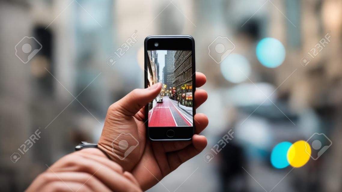 Una persona que sostiene un teléfono con una imagen de una calle en la pantalla.
