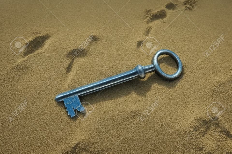 The sea washed up on the sandy beach an old vintage key to a treasure chest. The concept of success, luck and wealth.
