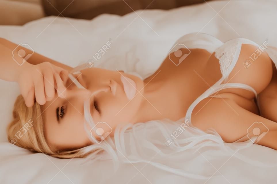Красивая девушка в белье лежит на кровати