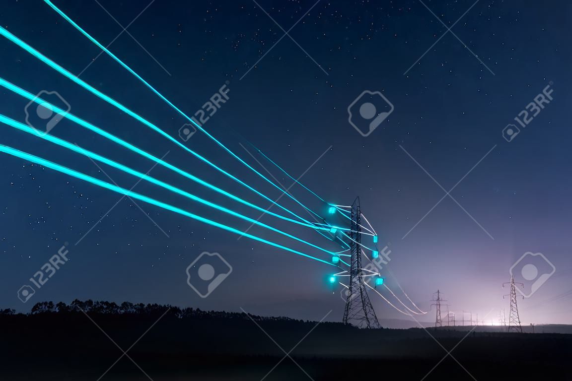 Tours de transmission d'électricité avec des fils incandescents contre le ciel étoilé. Notion d'énergie.