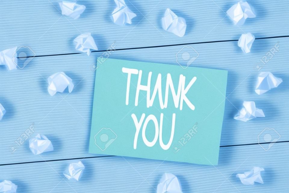 Word writing text Thank You. Business photo showcasing a polite expression used when acknowledging a gift or service Crumpled colored rectangle square shaped paper reminder white wood desk