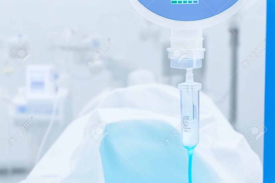 Close up 0.9% solución salina normal o goteo de cloruro de sodio para el paciente y la bomba de infusión en la emergencia, sala de operaciones en el hospital por el médico, el concepto de pasillo médico