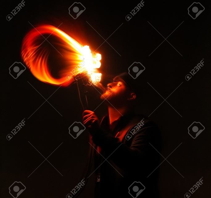 Feuershow Künstler atmen Feuer in der Dunkelheit
