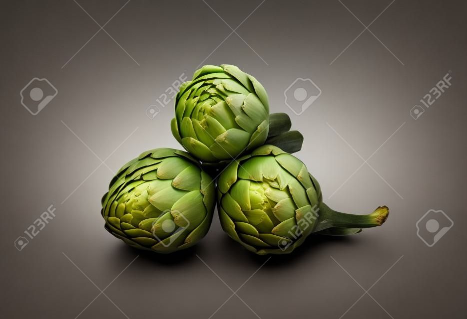Three artichokes with steam and leaf  Isolated 