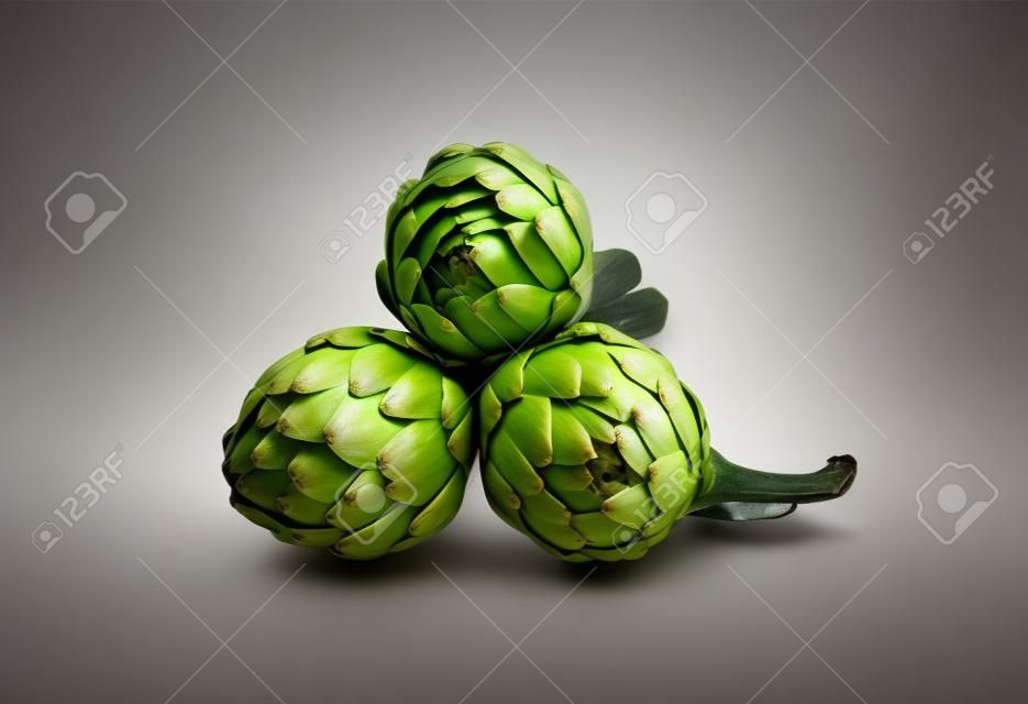 Three artichokes with steam and leaf  Isolated 