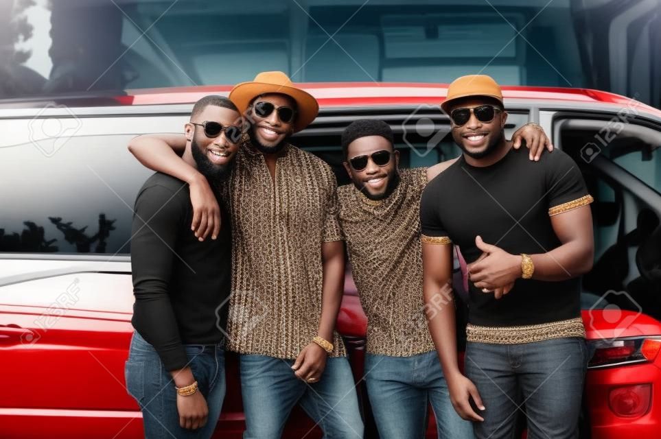 Los hombres negros que usan ropa tradicional fresca se colocan en la minivan.
