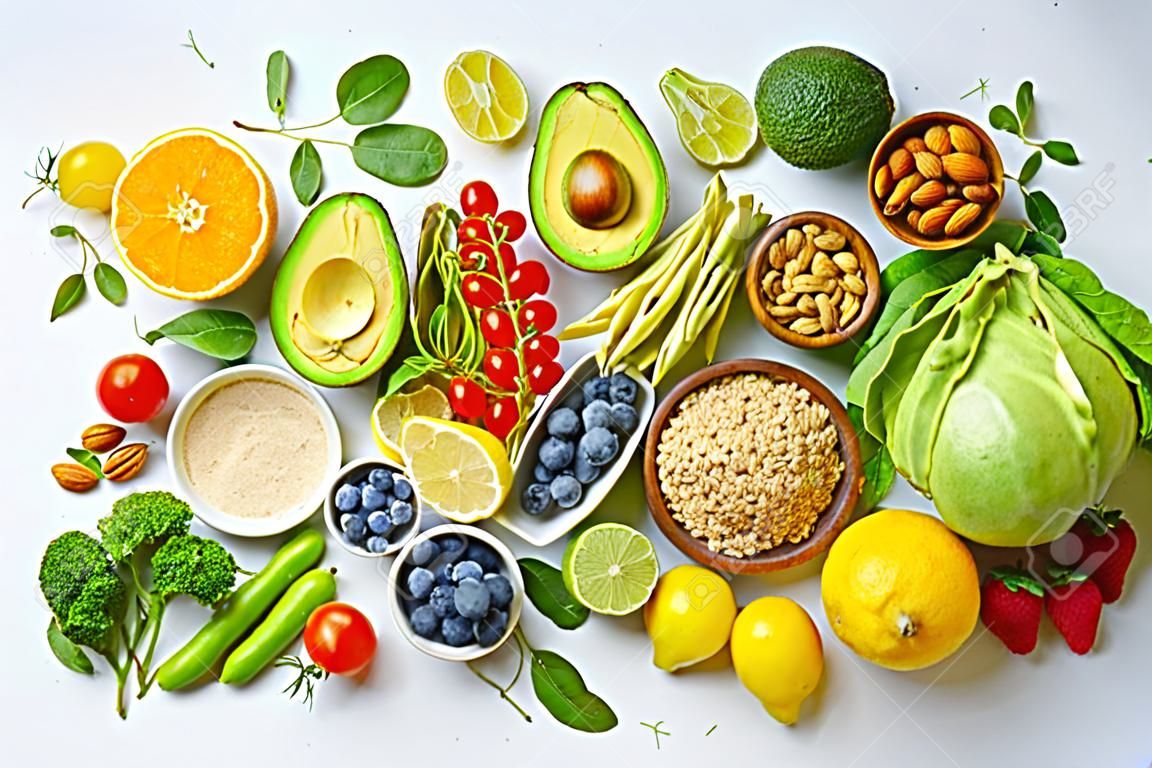 건강에 좋은 채식 식사 재료로 구성된 구색이 평평합니다. 날 음식 개념입니다. 아보카도를 곁들인 다양한 유기농 과일, 견과류, 딸기 및 야채. 비건 메뉴