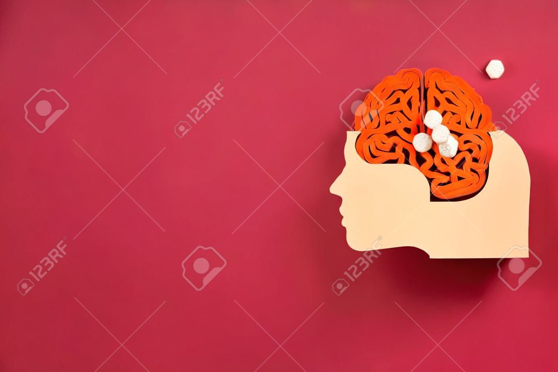 Paper head with decorative brain on red background, space for text