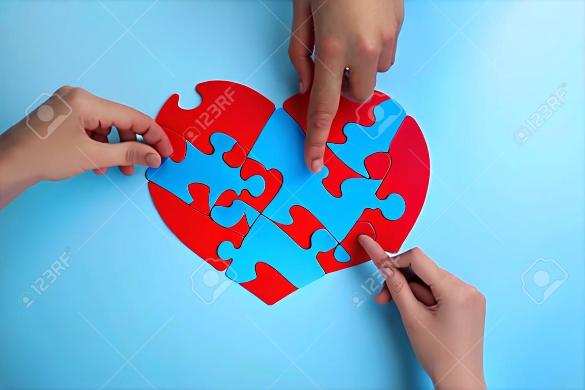 Red heart from puzzles on a blue background. blood donation