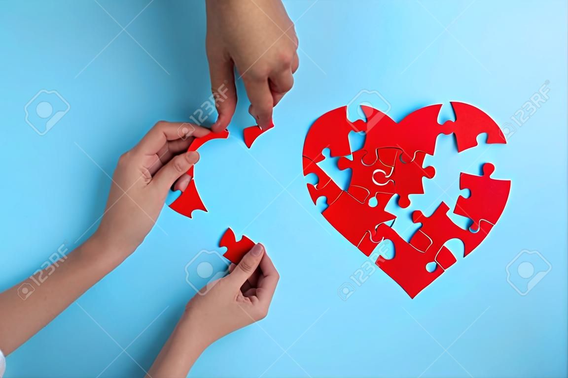 Red heart from puzzles on a blue background. blood donation