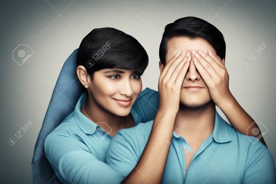 Woman covering a man's eyes