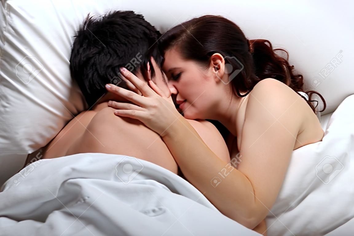 Cariñosa pareja besándose en la cama