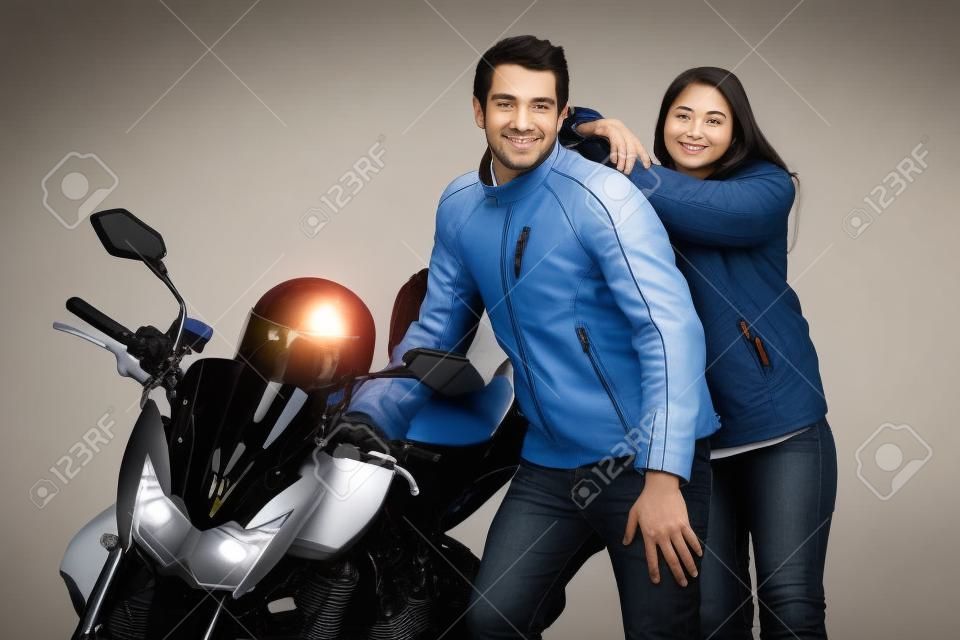 Couple posing next to motorcycle