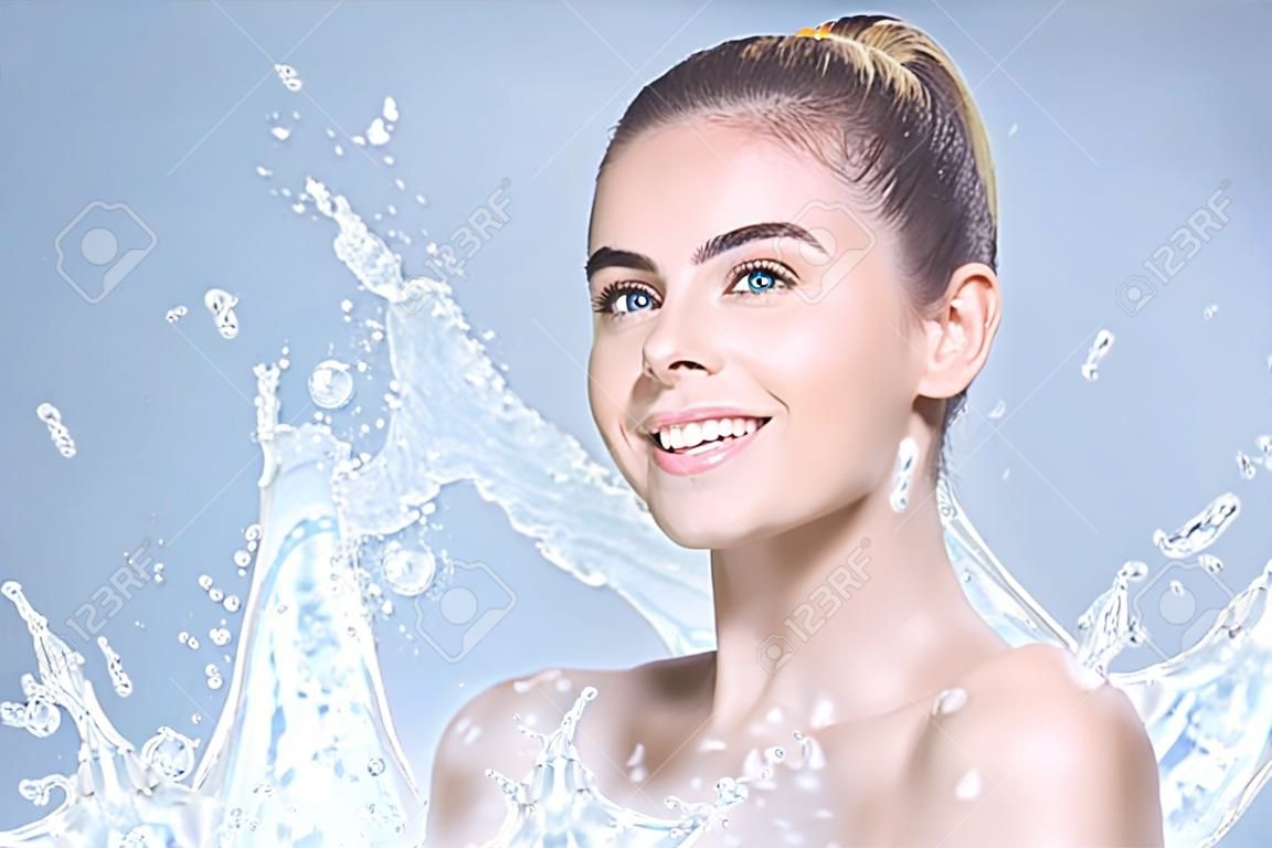Young beautiful woman portrait with water splashes. Body and skin care wash in bathroom or showering concept