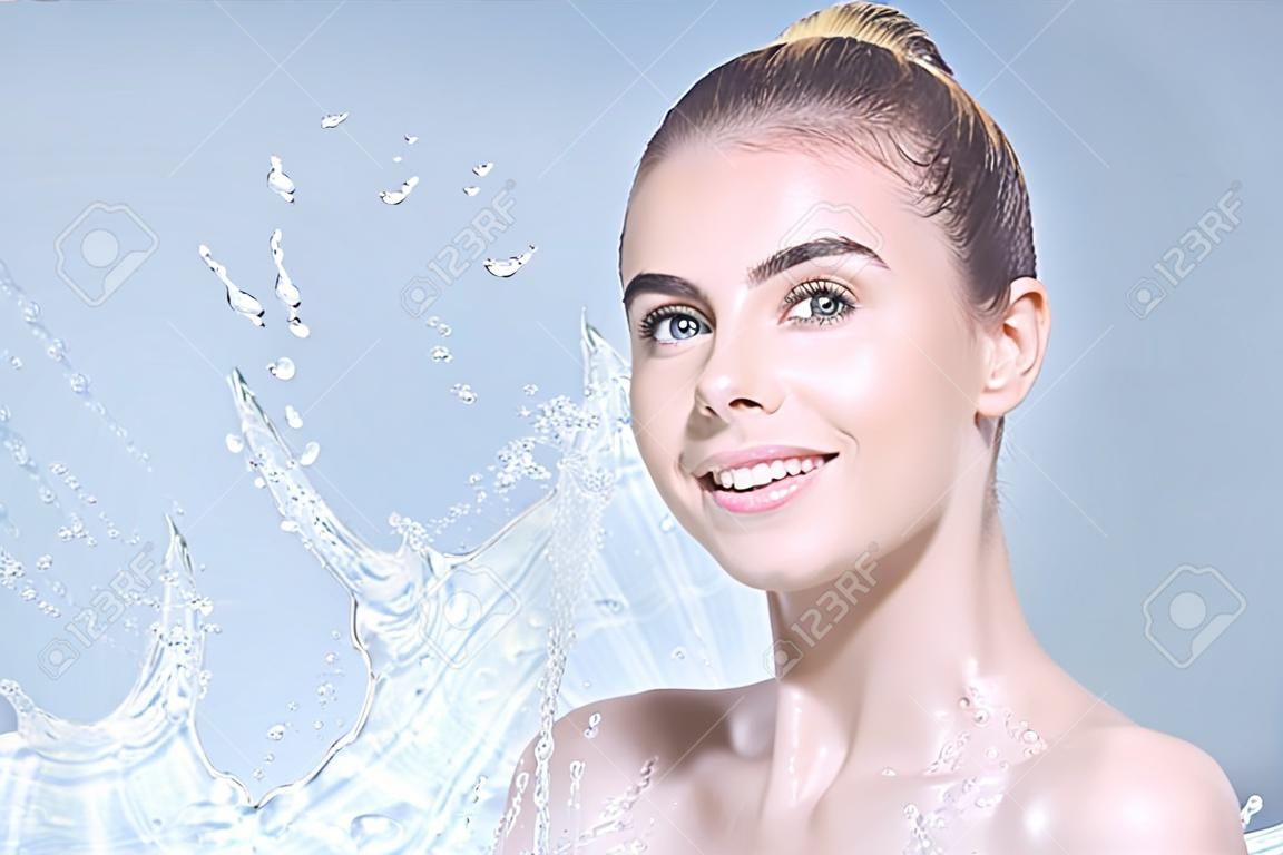 Young beautiful woman portrait with water splashes. Body and skin care wash in bathroom or showering concept