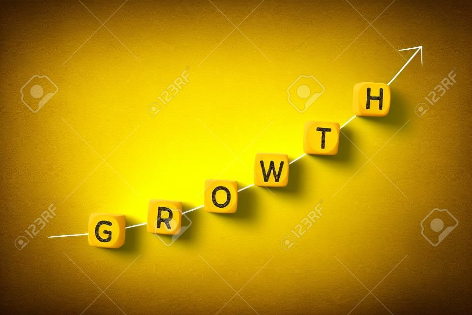 Concetto di crescita. Freccia in aumento e parola su blocchi di legno su sfondo giallo. Copia spazio