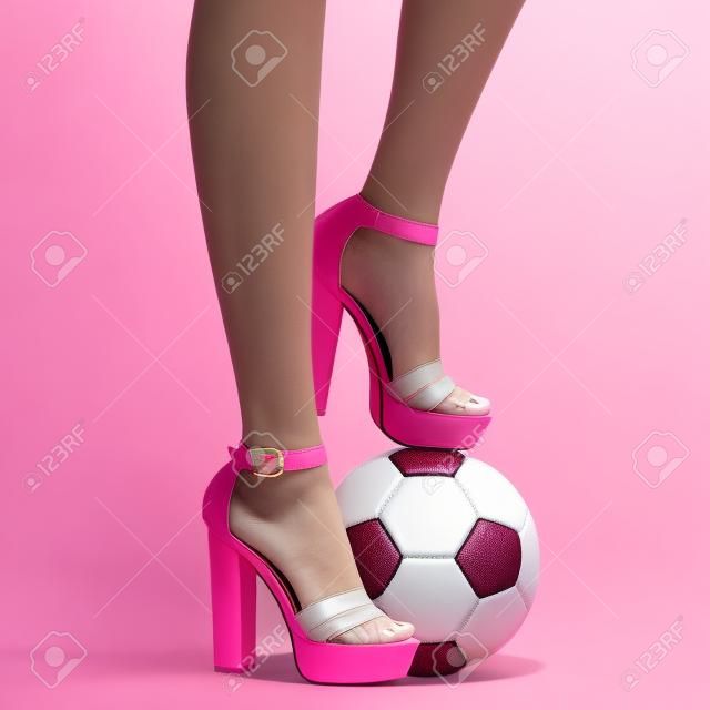 ピンクのヒールサンダルとサッカーボールの女性の足
