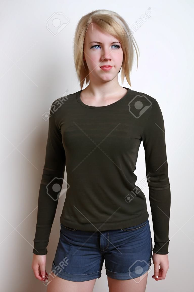Three quarter length blue-eyed blonde confident young woman standing