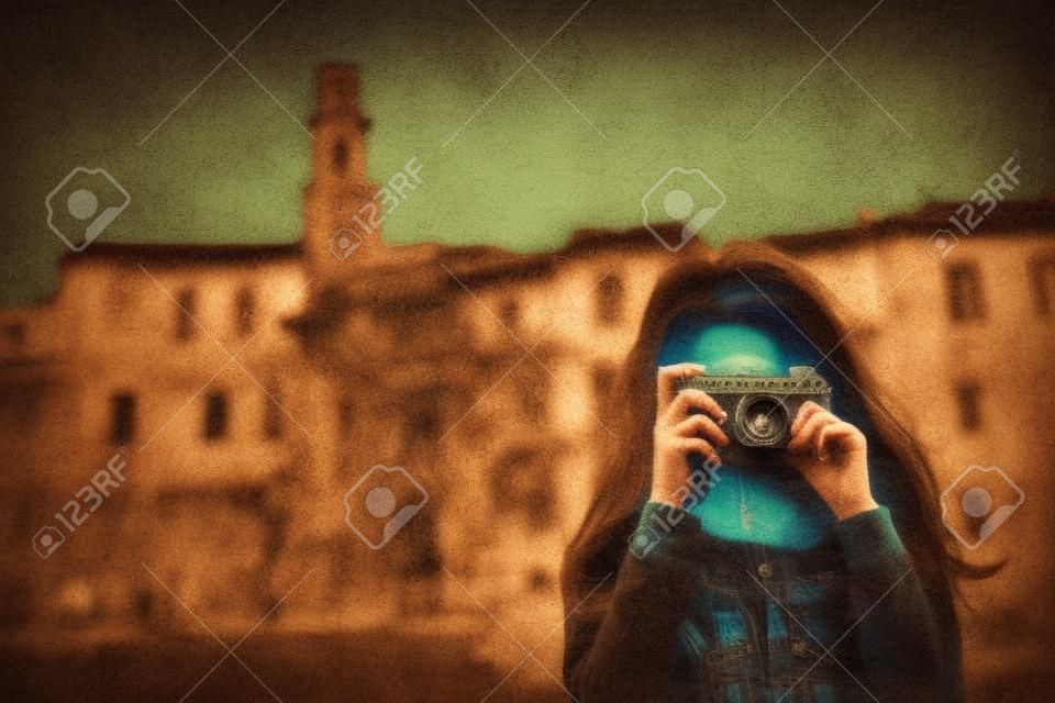 Girl with retro camera talking pictures outdoors, Italy, Pitigliano. Tuscany