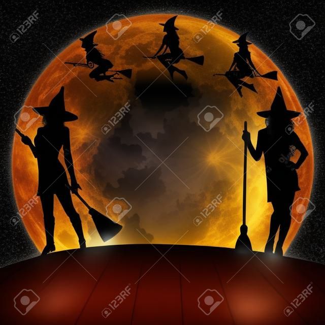 le streghe di Halloween volare sulla scopa e in piedi su sfondo luminoso ingannare luna.