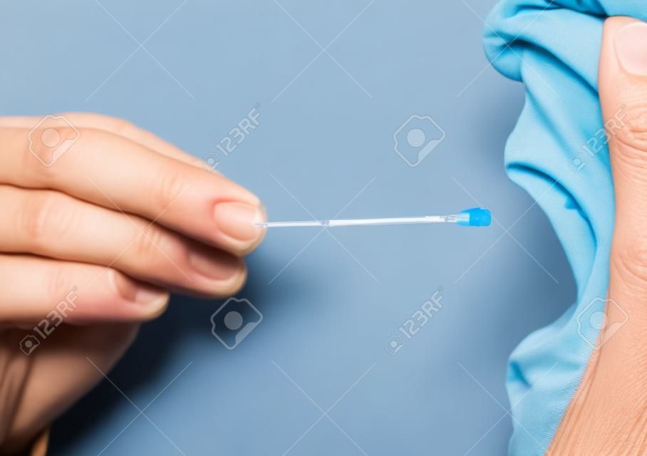 Mão Gloved tomando uma amostra de fluido corporal para teste de DNA de pessoa do sexo masculino sênior