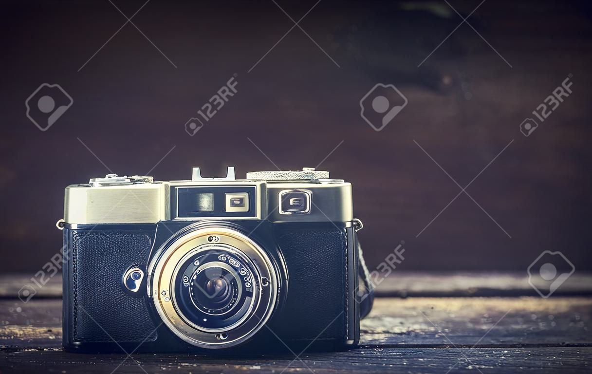Old camera on wooden background with blank sapce on the right side