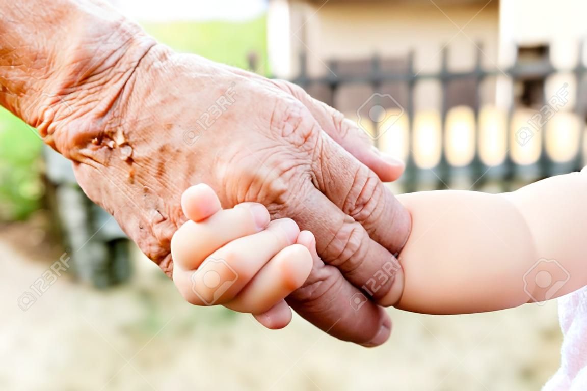 Wnuczka trzymając dziadka za rękę, selektywne fokus
