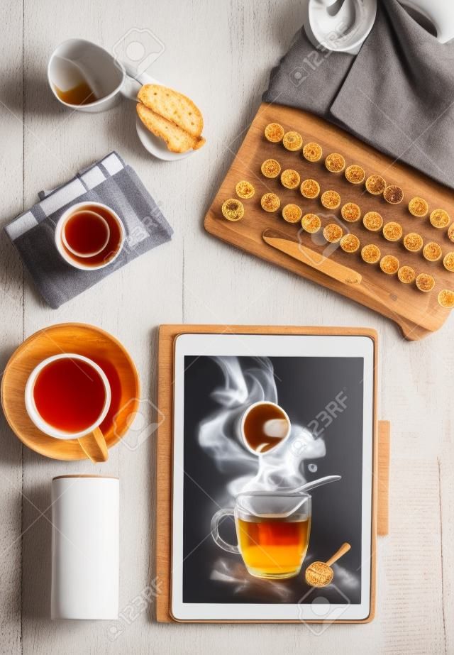 Concepto de blog de alimentos con taza de té en la pc de la tableta en el escritorio de madera