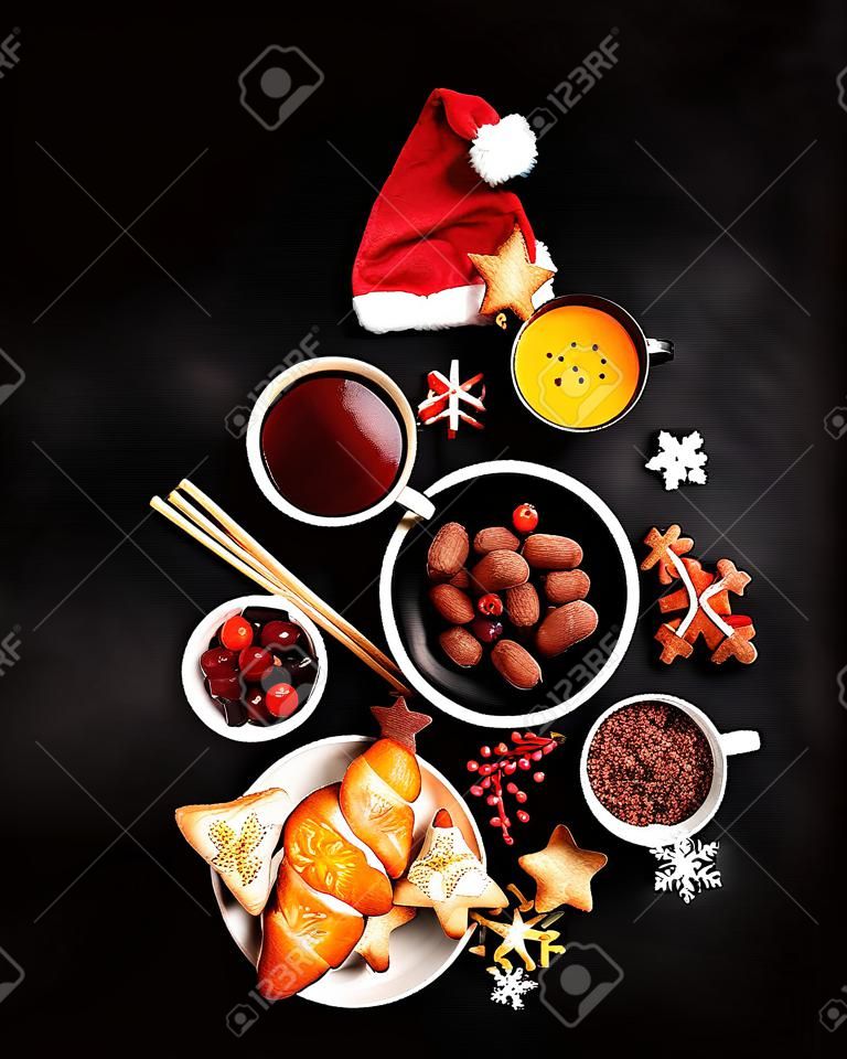 Christmas Tree made of holiday food on black background. Top view, flat lay with copy space. Christmas concept. New Year Holidays background.