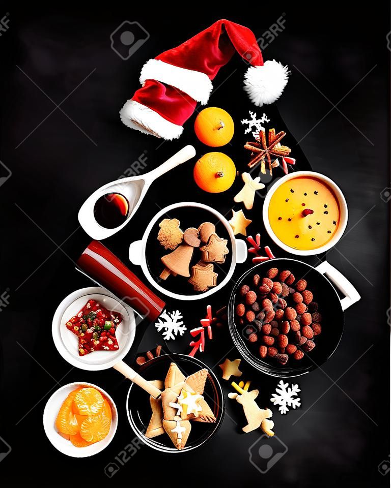 Christmas Tree made of holiday food on black background. Top view, flat lay with copy space. Christmas concept. New Year Holidays background.