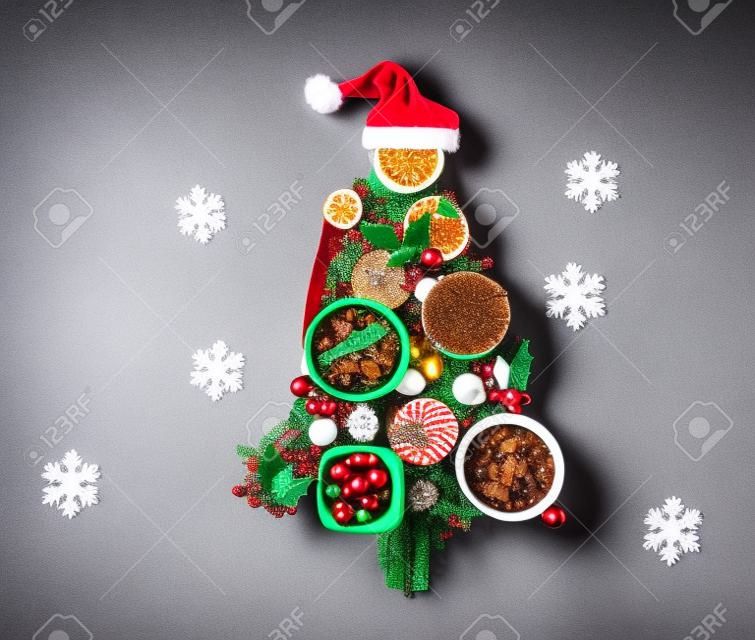 Árbol de Navidad hecho de comida festiva sobre fondo de hormigón. Vista superior, endecha plana. concepto de navidad. Fondo de vacaciones de año nuevo.