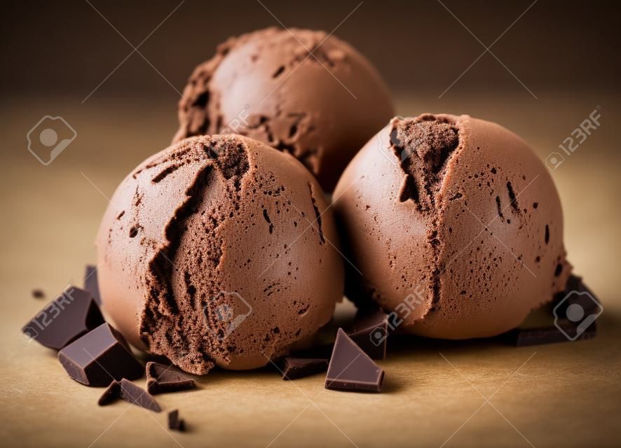 trois boules de crème glacée au chocolat brun isolés sur fond blanc