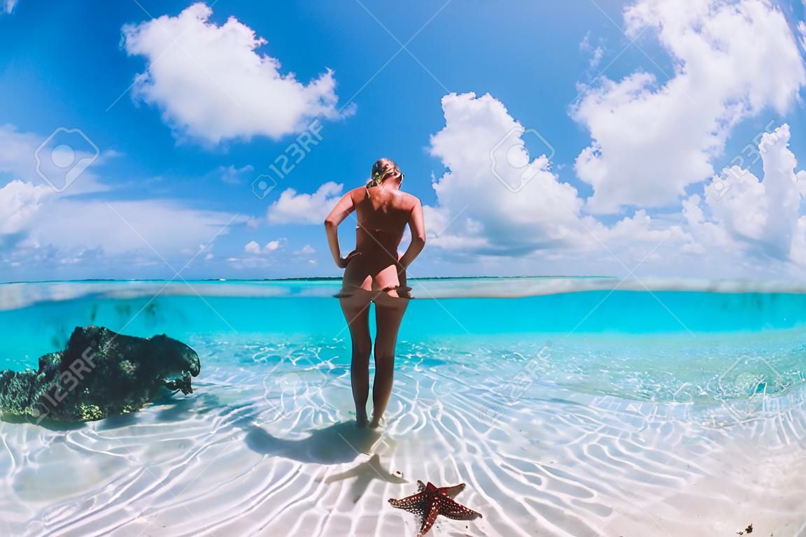 Schöne Frau posiert im tropischen Meer mit Seesternen, Bahamas-Inseln