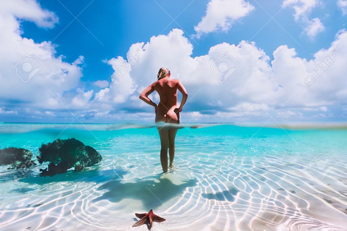 Belle femme posant en mer tropicale avec des étoiles de mer, îles Bahamas