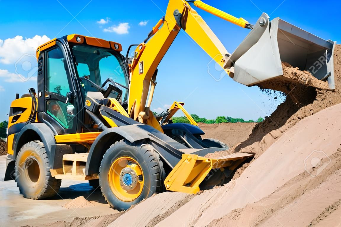 Excavator machine unloading sand with water during earth moving works at construction site