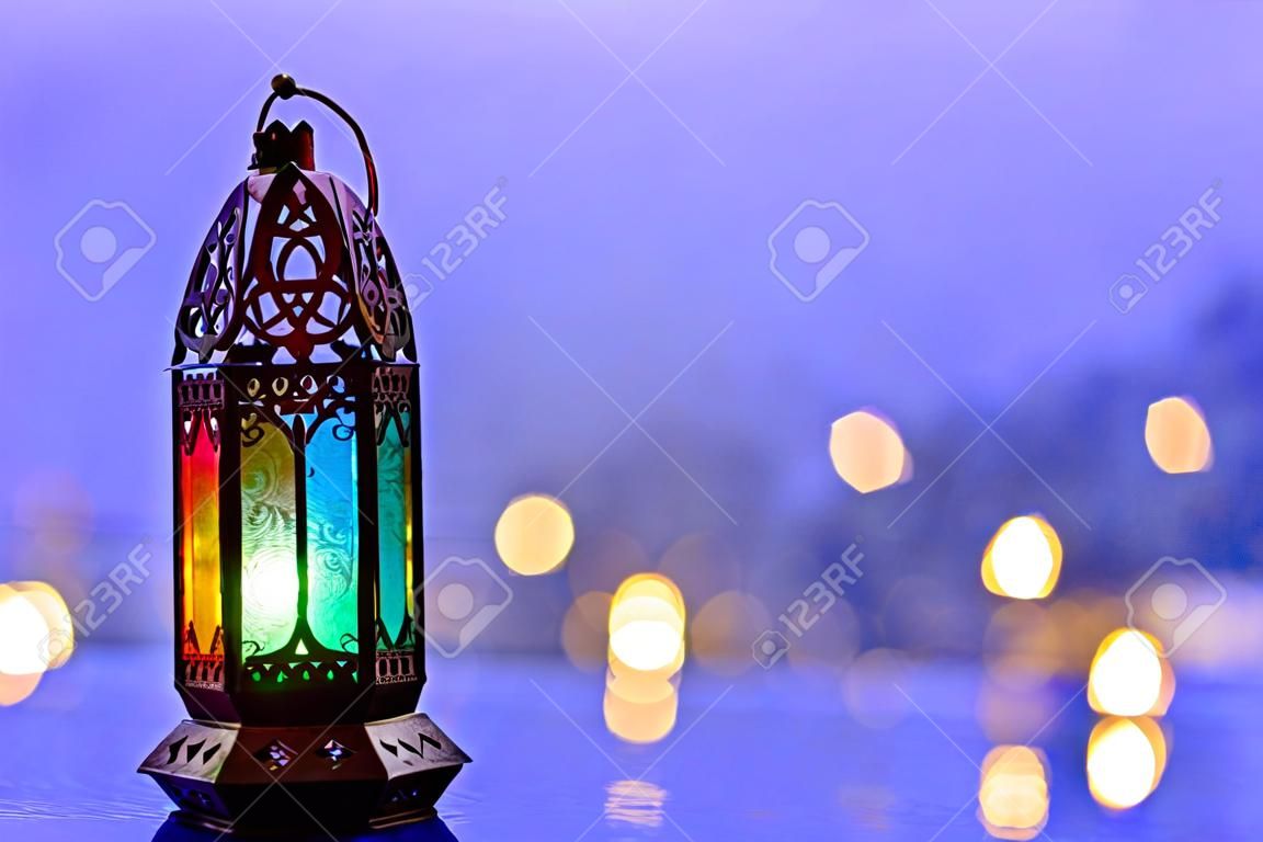 Lantaarn met lichten versieren voor islamitische nieuwjaar geplaatst op het raam met wazige blauwe achtergrond.