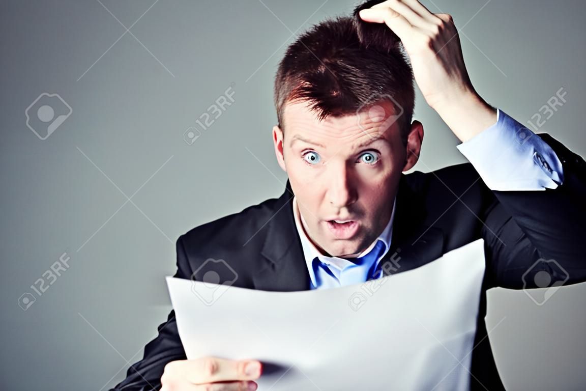 terrified businessman reads contract and pulls his hair from head