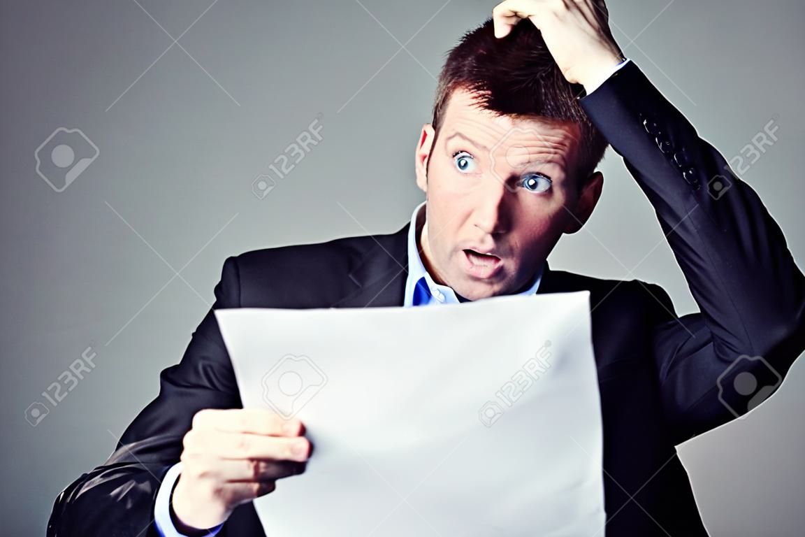 terrified businessman reads contract and pulls his hair from head